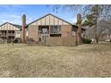 Condo's backyard with a well-maintained lawn, partial fence, and a screened-in porch at 2207 Rome Dr # B, Indianapolis, IN 46228