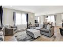 Inviting living room with a comfortable gray sofa, stylish decor, and large windows providing natural light at 2705 Grassy Branch Dr, Whitestown, IN 46075