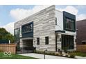 Eye-catching home featuring stone and siding, paired with black frame windows, and gated driveway at 2719 Carrollton Ave, Indianapolis, IN 46205