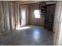 An unfinished basement showing a doorway leading outside and a black spiral staircase at 3060 N Alaska Rd, Cloverdale, IN 46120