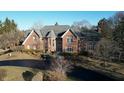 Aerial view of a brick home with a grey roof, landscaped front yard, and long paved driveway at 3370 Walnut Creek Ct, Carmel, IN 46032