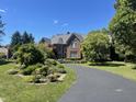 Paved driveway leading to a brick home with a well-maintained front yard and mature landscaping at 3370 Walnut Creek Ct, Carmel, IN 46032