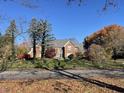 Beautiful brick home with a landscaped front yard featuring mature trees and colorful foliage at 3370 Walnut Creek Ct, Carmel, IN 46032