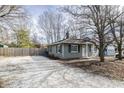 View of the side of the home with a gravel driveway and wooden privacy fence at 4221 Evanston Ave, Indianapolis, IN 46205