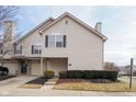 Townhome with a two-car garage, neutral siding, dark shutters, and manicured front yard at 475 Glenn Villa Ln # 144, Avon, IN 46123