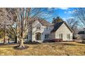 Charming two-story brick home with a well-manicured lawn and mature trees, reflecting classic suburban elegance at 4906 Willow Ridge Ct, Zionsville, IN 46077