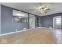 Spacious living room featuring wood floors, ceiling fan, and view into the dining room at 515 S East St, Plainfield, IN 46168