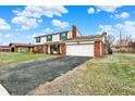 Charming two-story home with a spacious driveway and attached two-car garage with brick accent at 5549 Hollister Dr, Indianapolis, IN 46224