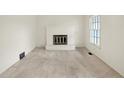 Cozy living room featuring a white fireplace, new carpet, and a window at 5549 Hollister Dr, Indianapolis, IN 46224