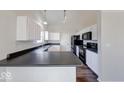 Bright kitchen featuring white cabinets, sleek black countertops, and modern appliances at 6608 Rushing, Noblesville, IN 46062