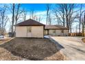 Lovely one story home with a brick exterior, attached garage, and a partially wooded front yard at 6775 W Woodcrest Dr, Greenfield, IN 46140
