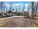 Beautiful one-story home with a brick exterior, attached garage, and a partially wooded front yard at 6775 W Woodcrest Dr, Greenfield, IN 46140