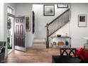 Bright entryway featuring hardwood floors, a staircase, and tasteful decor, creating a welcoming ambiance at 746 Astor Dr, Carmel, IN 46032