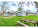 Spacious backyard featuring green grass, a picnic table, and mature trees offering ample shade at 7610 Brehob Rd, Indianapolis, IN 46217