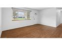 Bright living room with hardwood floors, a large window, and a view of the front yard at 7610 Brehob Rd, Indianapolis, IN 46217