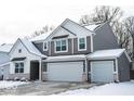 Two-story home with gray siding, white trim, two-car garage, and snow-covered roof and yard at 8623 Lester Pl, Pendleton, IN 46064