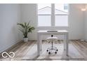 Well-lit office space with a modern desk, rolling chair, a large window, and hardwood floors at 8623 Lester Pl, Pendleton, IN 46064