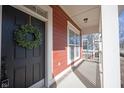 Close-up of front door with wreath and covered porch with white columns and plenty of sunlight at 12964 Walbeck Dr, Fishers, IN 46037