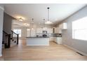Modern kitchen boasts a large island with black countertops and stainless steel appliances at 12964 Walbeck Dr, Fishers, IN 46037