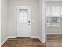 Bright entryway features a white door with glass insert, leading to rooms with hardwood floors at 15949 Black Willow Ln, Fishers, IN 46040