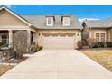 A home with a two-car garage and a long driveway, complemented by manicured landscaping and a mix of textures at 163 Bridgemor Ln, Mooresville, IN 46158