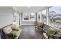 Bright sunroom with multiple windows, wood-look flooring, neutral paint, and cozy seating arrangements at 1818 Arlene Dr, Indianapolis, IN 46219