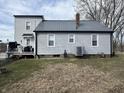Rear exterior view of the house, highlighting the siding, updated windows, and well-manicured lawn at 1905 Apple St, Greenfield, IN 46140