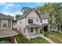 Angle view of the home featuring a covered front porch, landscaping, and an inviting facade at 206 N Hamilton Ave, Indianapolis, IN 46201