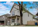 View of the home showcasing its covered front porch, landscaping, and neutral color palette at 206 N Hamilton Ave, Indianapolis, IN 46201