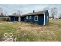 Exterior of the home featuring blue siding and a partially fenced yard at 3039 N Campbell Ave, Indianapolis, IN 46218