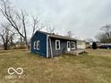 Exterior view of the home featuring blue siding and a modest yard at 3039 N Campbell Ave, Indianapolis, IN 46218