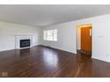 Bright living room featuring a fireplace, hardwood floors, and a large window for natural light at 3233 E 48Th St, Indianapolis, IN 46205
