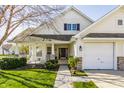 Inviting home featuring a two-car garage, front porch, manicured lawn, and charming architectural details at 3841 Constitution Dr, Carmel, IN 46032