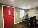 Dining area with a modern glass-top table, black chairs, and a bright red entry door at 422 Johnson Ave, Franklin, IN 46131