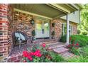 Inviting front porch featuring a cozy sitting area, double doors, and blooming flowers at 502 Ironwood Dr, Carmel, IN 46033