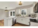 Bright kitchen featuring white cabinets, stainless steel appliances, quartz countertops, and a view into the yard at 502 Ironwood Dr, Carmel, IN 46033