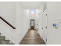 Welcoming hallway with wood floors, bright white walls, and a stylish front door at 5421 Landing Place Ln, Noblesville, IN 46062