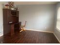 Home office featuring dark wood floors, light blue walls, and a built-in desk at 5801 Safari Dr, Indianapolis, IN 46237