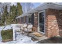 Inviting front porch with seating, brick facade, and seasonal decorations at 5818 S Madison Ave, Anderson, IN 46013