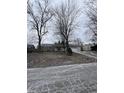 A single-Gathering home with mature trees in the front yard on an overcast day at 6533 Parker Ln, Indianapolis, IN 46220