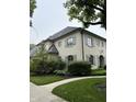 Two-story house with light brick and gray shutters, complemented by lush landscaping and a sidewalk at 7525 N Pennsylvania St, Indianapolis, IN 46240