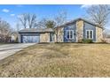 Charming home with a stone and siding exterior, an attached garage, and a manicured lawn at 8305 Warbler Way, Indianapolis, IN 46256