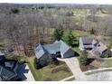 Aerial view of a charming home featuring a manicured lawn, mature trees, and a convenient two-car garage at 1086 Pebble Brook Dr, Noblesville, IN 46062