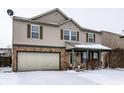 Charming two-story home with a front-facing two-car garage and snow-covered front yard at 10991 Clear Spring Dr, Camby, IN 46113