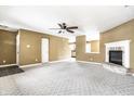 Open concept living room featuring a ceiling fan, carpet, and fireplace with brick hearth at 10991 Clear Spring Dr, Camby, IN 46113