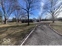 Scenic view of the front yard showcasing the home's expansive lawn and mature trees at 11012 Brooks School Rd, Fishers, IN 46037