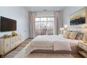 Bright main bedroom boasts natural light, balcony access, modern furniture, and soft bedding for a comfortable retreat at 15 W Executive Dr # 104, Carmel, IN 46032