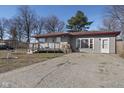 Gray home with a welcoming front porch and a small yard, featuring a convenient driveway and neat landscaping at 2610 Caroline Ave, Indianapolis, IN 46218