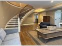 Cozy living area with an open floor plan, hardwood floors, and elegant staircase at 307 S Main St, Whitestown, IN 46075