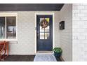 Close-up of a stylish blue front door adorned with a wreath and adjacent to a mailbox at 5240 E 10Th St, Indianapolis, IN 46219